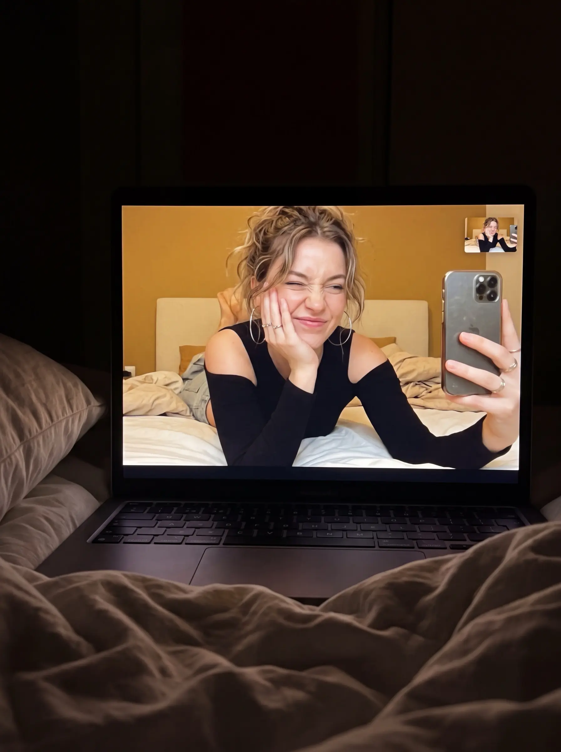 Laptop screen showing a woman making a playful face during a video call